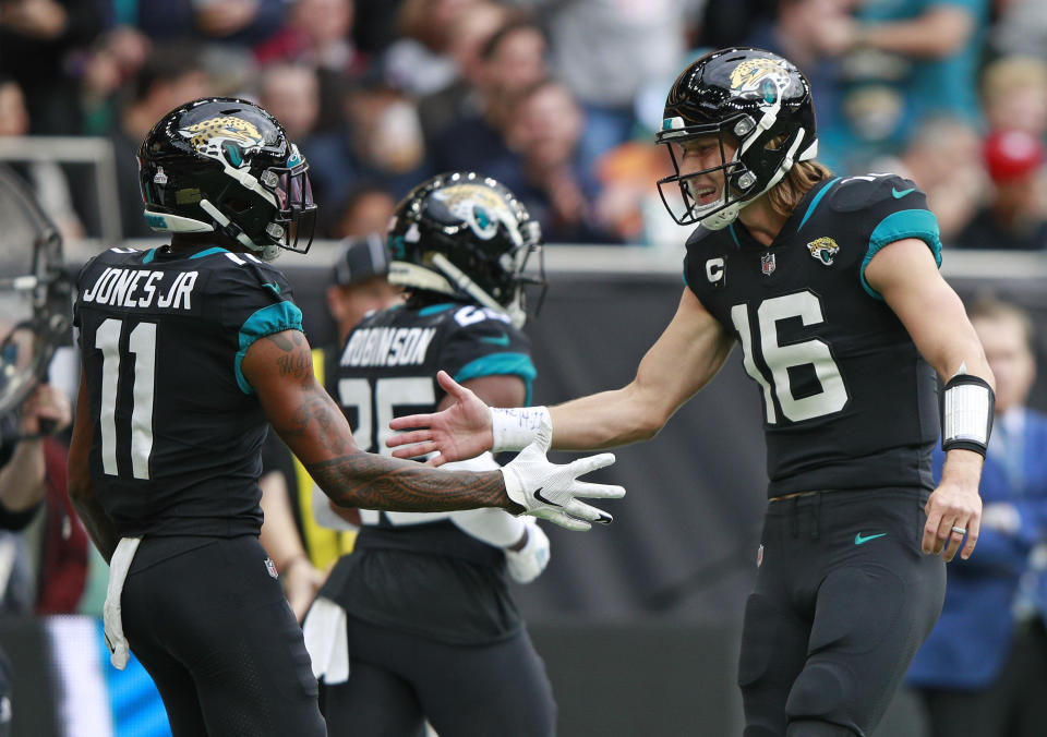 Jacksonville Jaguars quarterback Trevor Lawrence (16) celebrates with Jacksonville Jaguars wide receiver Marvin Jones (11) after they combined to score a touchdown during the first half of an NFL football game between the Miami Dolphins and the Jacksonville Jaguars at the Tottenham Hotspur stadium in London, England, Sunday, Oct. 17, 2021. (AP Photo/Ian Walton)