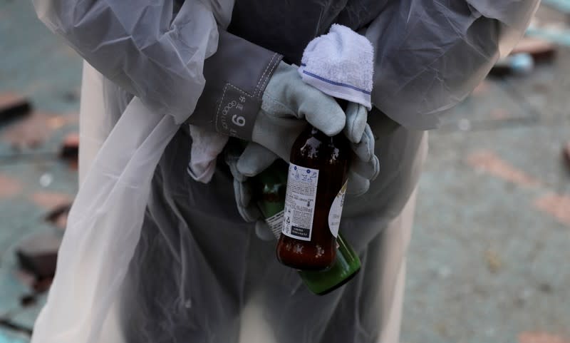 An anti-government protester holds bottles during clashes with police, outside Hong Kong Polytechnic University