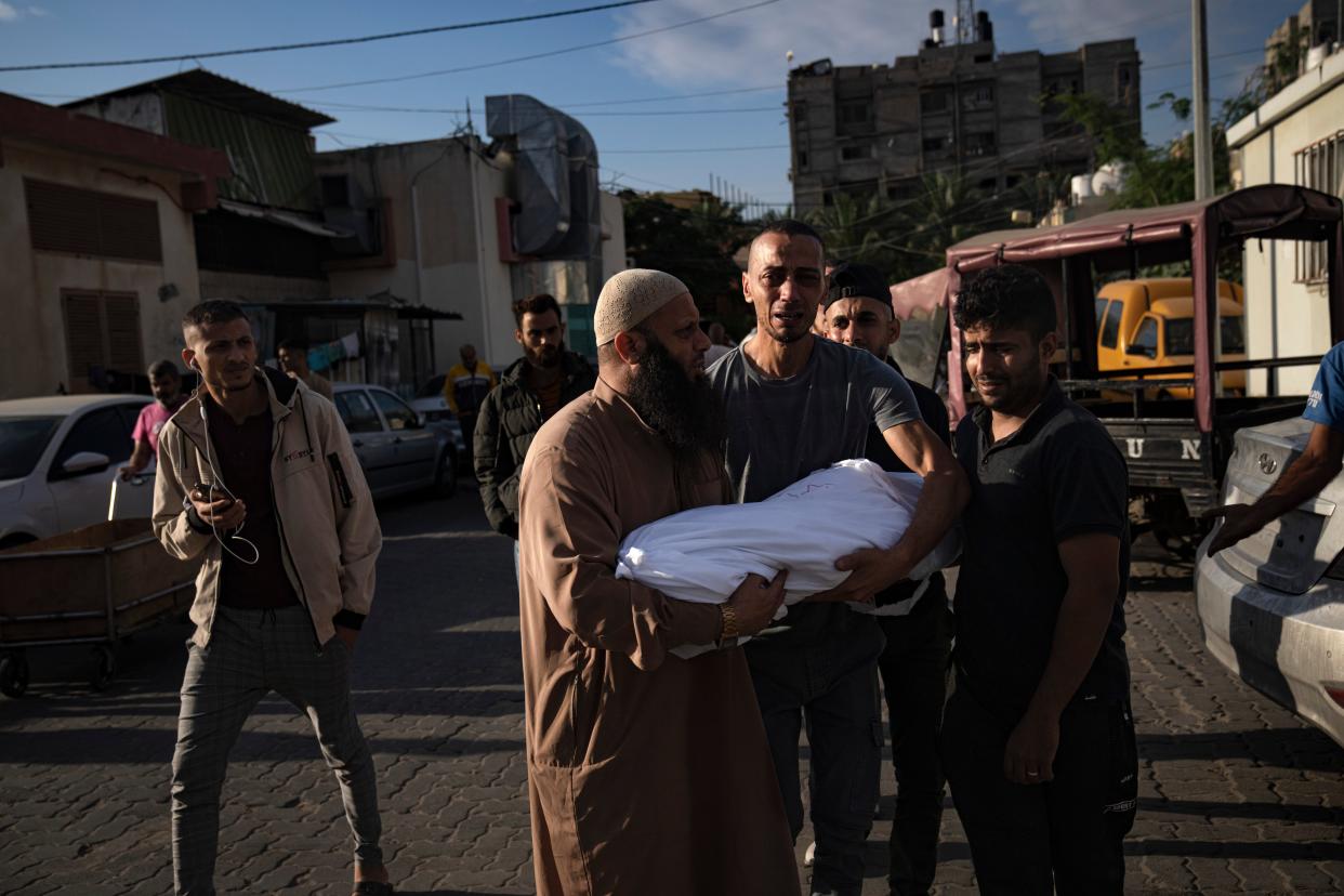 Palestinian carry a child killed d in the Israeli bombardment of the Gaza Strip in a morgue in Khan Younis (Copyright 2023 The Associated Press. All rights reserved.)