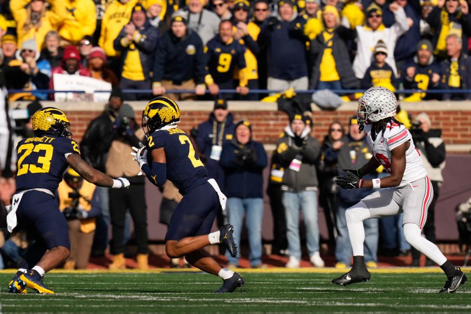 Nov 25, 2023; Ann Arbor, Michigan, USA; Michigan Wolverines defensive back Will Johnson (2) intercepts a pass intended for Ohio State Buckeyes wide receiver Marvin Harrison Jr. (18) during the NCAA football game at Michigan Stadium. Ohio State lost 30-24.