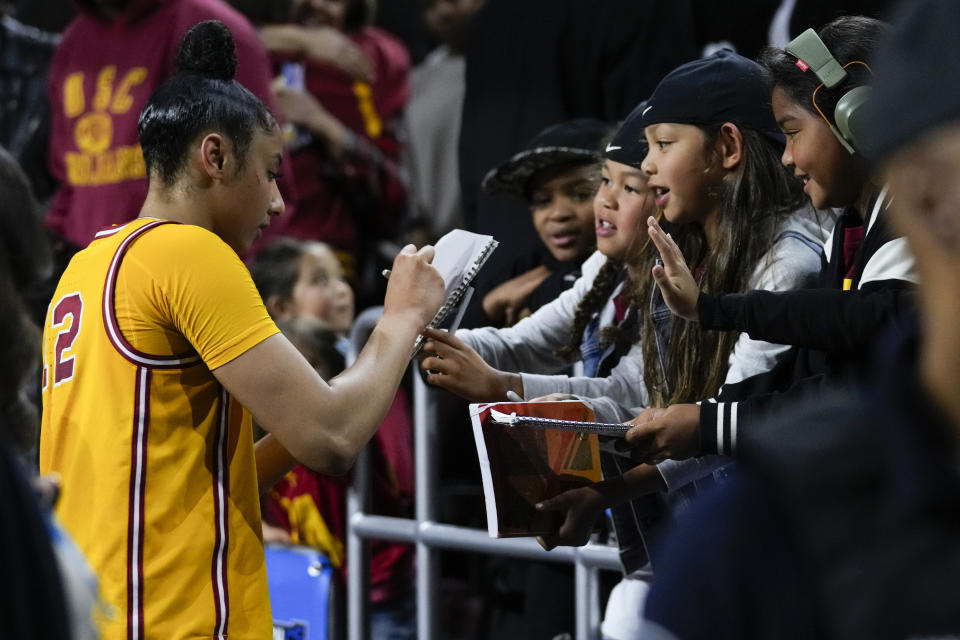 Southern California guard JuJu Watkins (12) signs autographs for fans after a 73-55 win over Kansas in a second-round college basketball game in the women's NCAA Tournament in Los Angeles, Monday, March 25, 2024. (AP Photo/Ashley Landis)