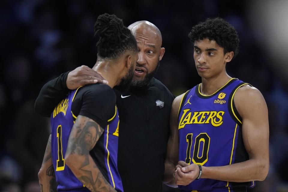 El entrenador en jefe de los Lakers, Darvin Ham, centro, habla con los guardias D'Angelo Russell, izquierda, y Max Christie el viernes por la noche.