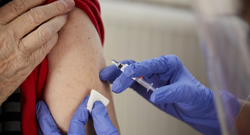 Woman receives vaccine shot.