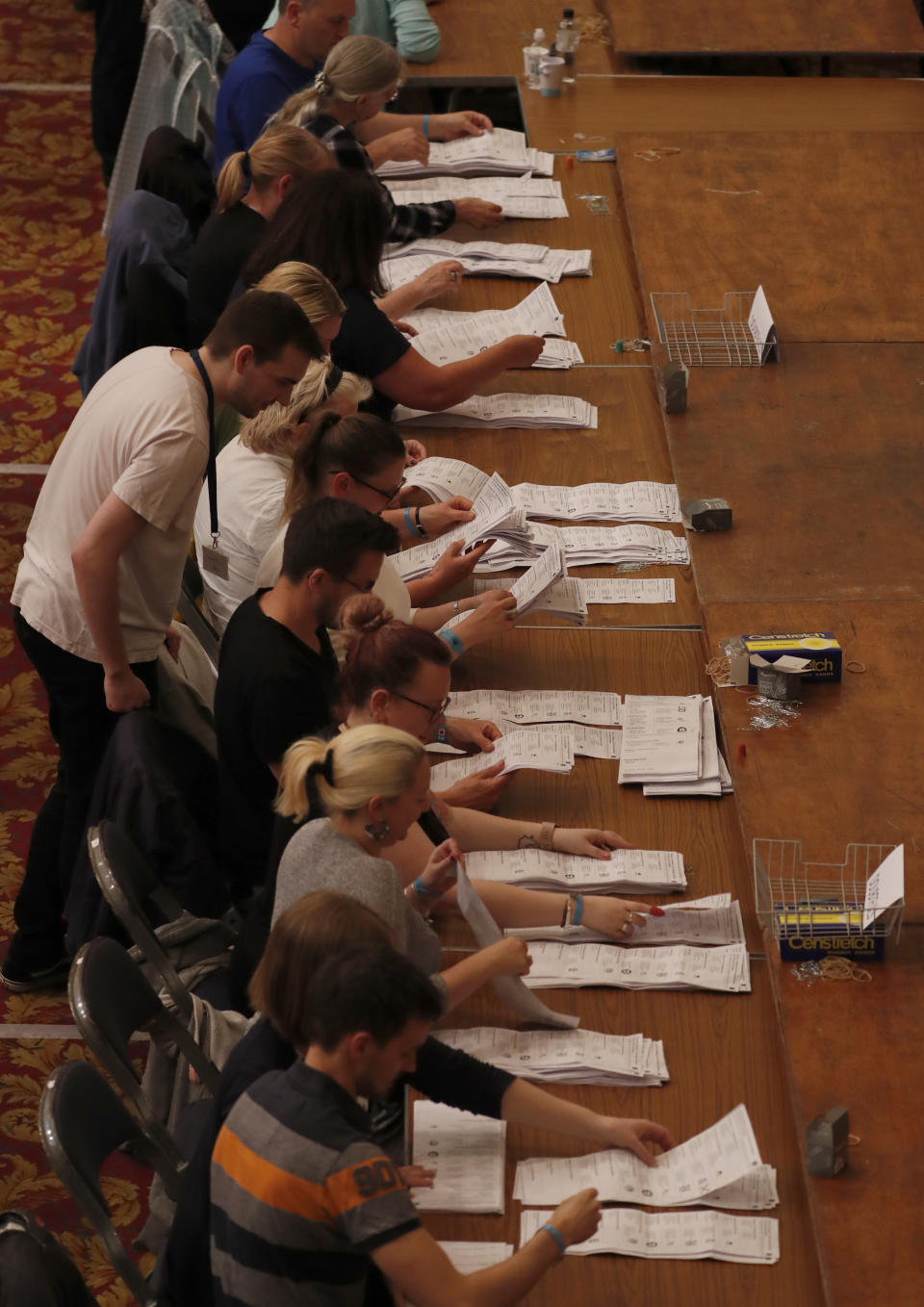 Official counters sort votes cast into different piles during counting for the European Elections for the South East England region, in Southampton, England, Sunday, May 26, 2019. (AP Photo/Alastair Grant)