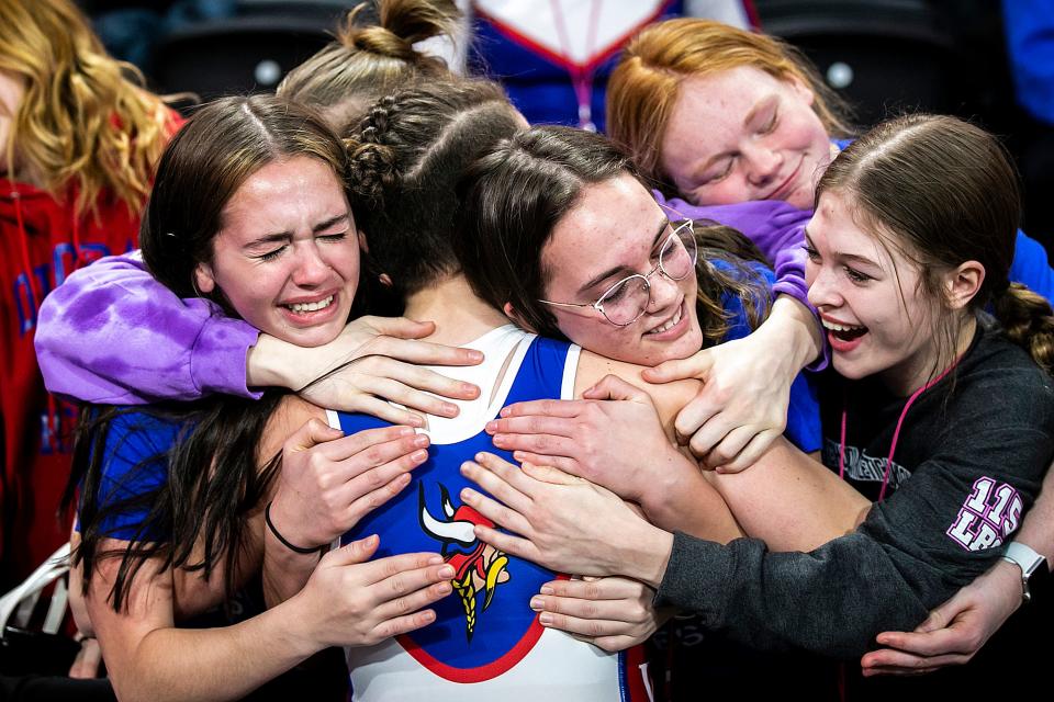 Decorah's Naomi Simon is embraced by teammates after scoring a fall at 170 pounds in the state finals last season.