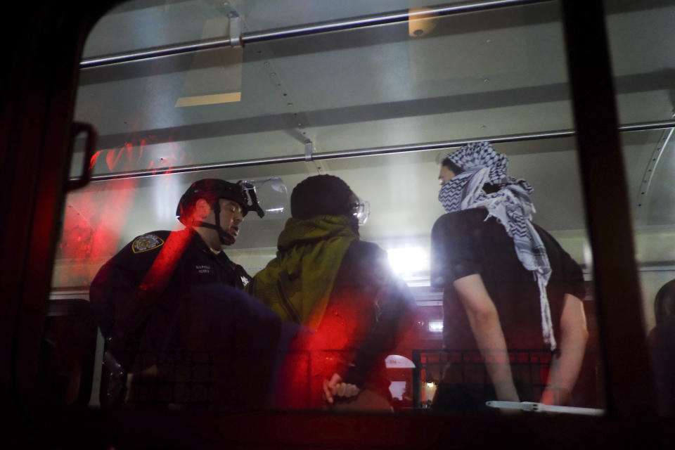 FILE - Members of the New York Police Department strategic response team load arrested protesters from Columbia University onto a bus, Tuesday, April 30, 2024, in New York. Dozens of Columbia University students who were arrested for occupying a campus building as part of a pro-Palestinian protest will have their criminal charges dropped, prosecutors said. (AP Photo/Julius Motal, File)