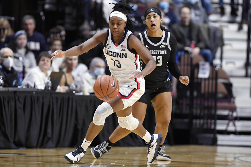 Connecticut's Christyn Williams (13) steals the ball from Georgetown's Milan Bolden-Morris (23) in the first half of an NCAA college basketball game in the quarterfinals of the Big East Conference tournament at Mohegan Sun Arena, Saturday, March 5, 2022, in Uncasville, Conn. (AP Photo/Jessica Hill)