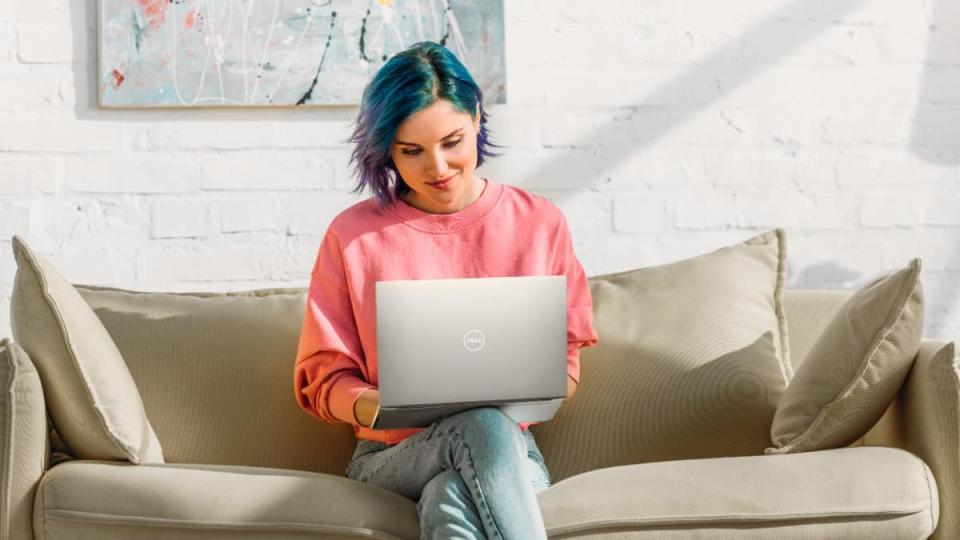 woman using dell xps 13 laptop on a couch