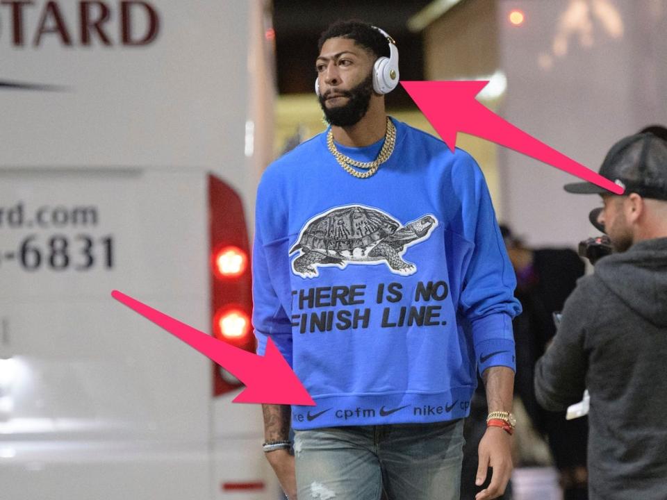 Anthony Davis arrives at a game wearing a Nike sweatshirt and Beats headphones.