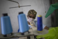 Jaqueline, from the Vila Isabel samba school makes a scrub fro medical workers to wear. during the new coronavirus pandemic in Rio de Janeiro, Brazil, Tuesday, April 7, 2020. Samba schools that a spend all year making Carnival costumes have turned their sewing machines to a different purpose, making scrubs and face masks for medical workers. (AP Photo/Silvia Izquierdo)