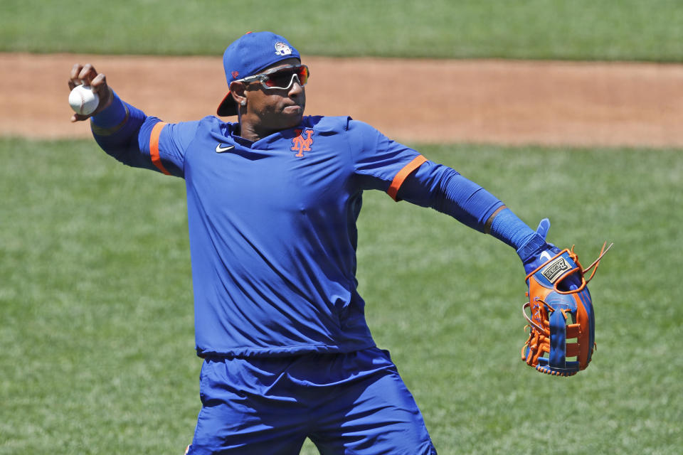 New York Mets left fielder Yoenis Cespedes stretches out to throw the ball as he waits for his turn in the batting cage during the afternoon session of a summer baseball training camp workout at Citi Field, Thursday, July 9, 2020, in New York. (AP Photo/Kathy Willens)