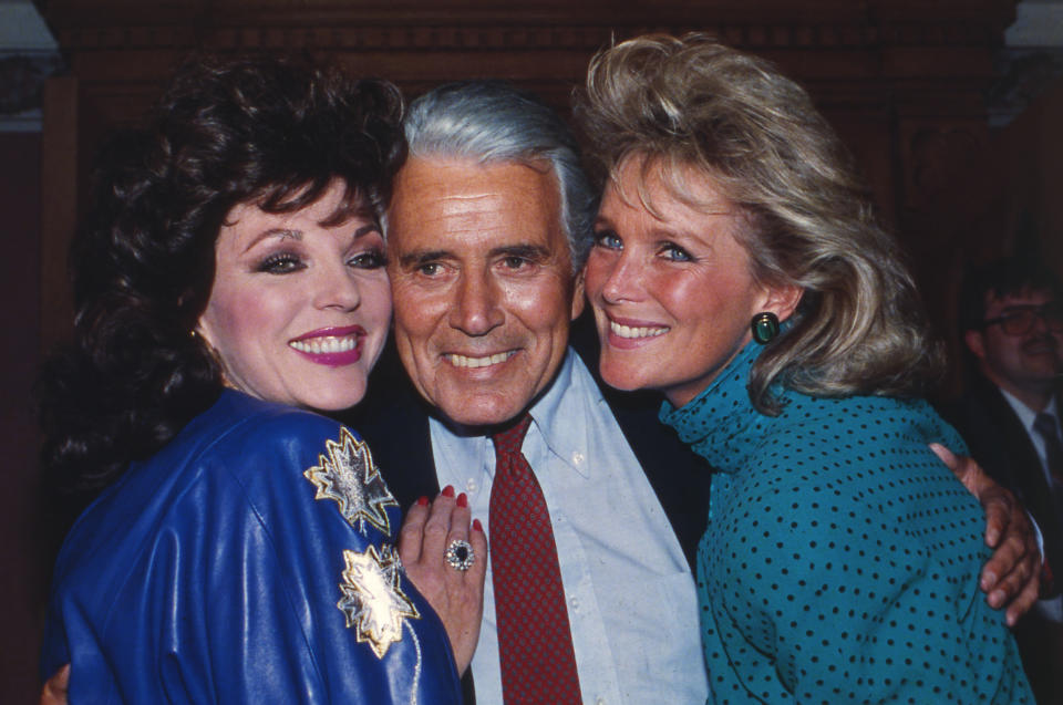 Actor John Forsythe is joined by "Dynasty" actresses Joan Collins, left and Linda Evans at a party celebrating the production of 150 episodes of the popular series in Los Angeles, USA, September 1986. (AP Photo/Reed Saxon)