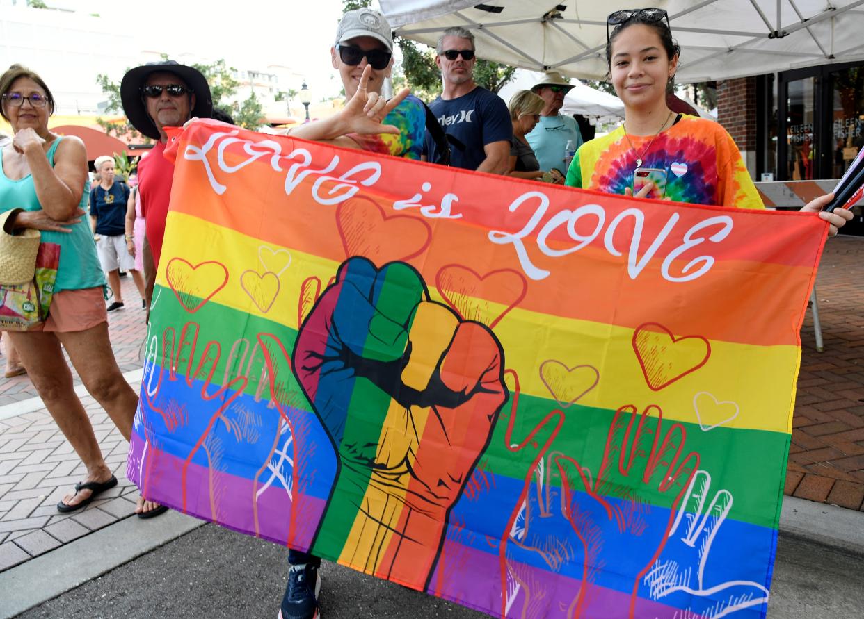 Participants display a flag of solidarity during the June 2022 Pride Car Parade in downtown Sarasota.