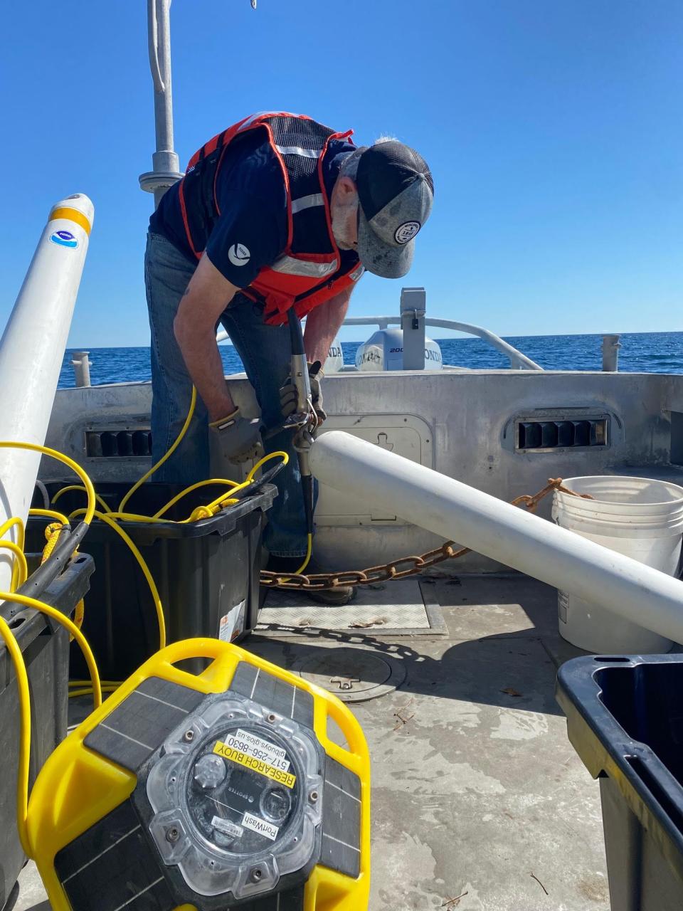 A sanctuary staff member prepares a weather buoy to be deployed near Two Rivers.