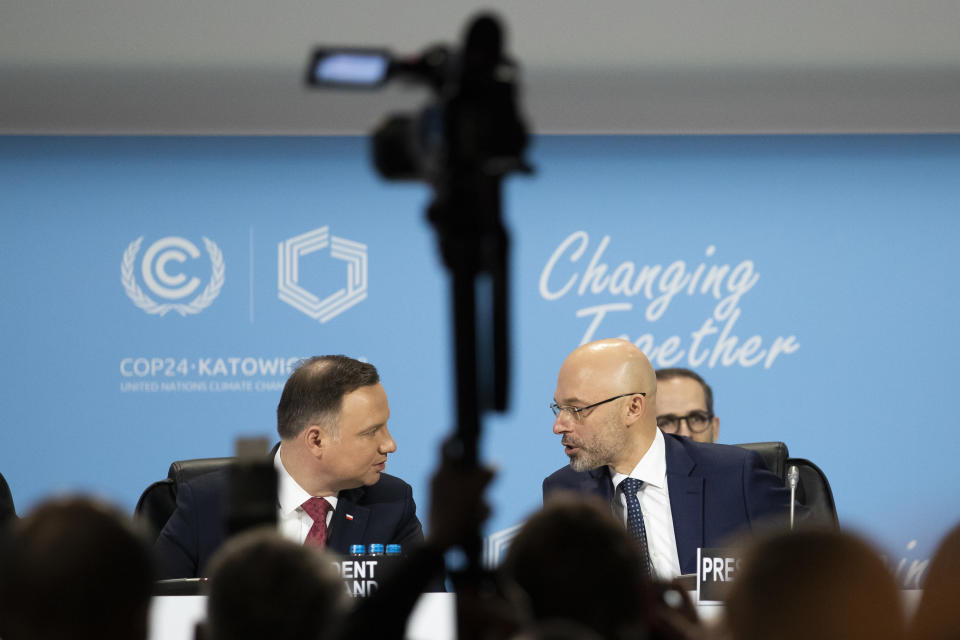 Michal Kurtyka, Polish Deputy Minister of the Environment and President of the COP24, right, talks to Andrzej Duda, President of Poland, left, during the COP24 United Nations Climate Change Conference in Katowice, Poland, Monday, Dec. 3, 2018. (Peter Klaunzer/Keystone via AP)