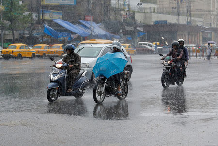People ride their motorbikes during heavy rains in Kolkata, India, May 3, 2019. REUTERS/Rupak De Chowdhuri
