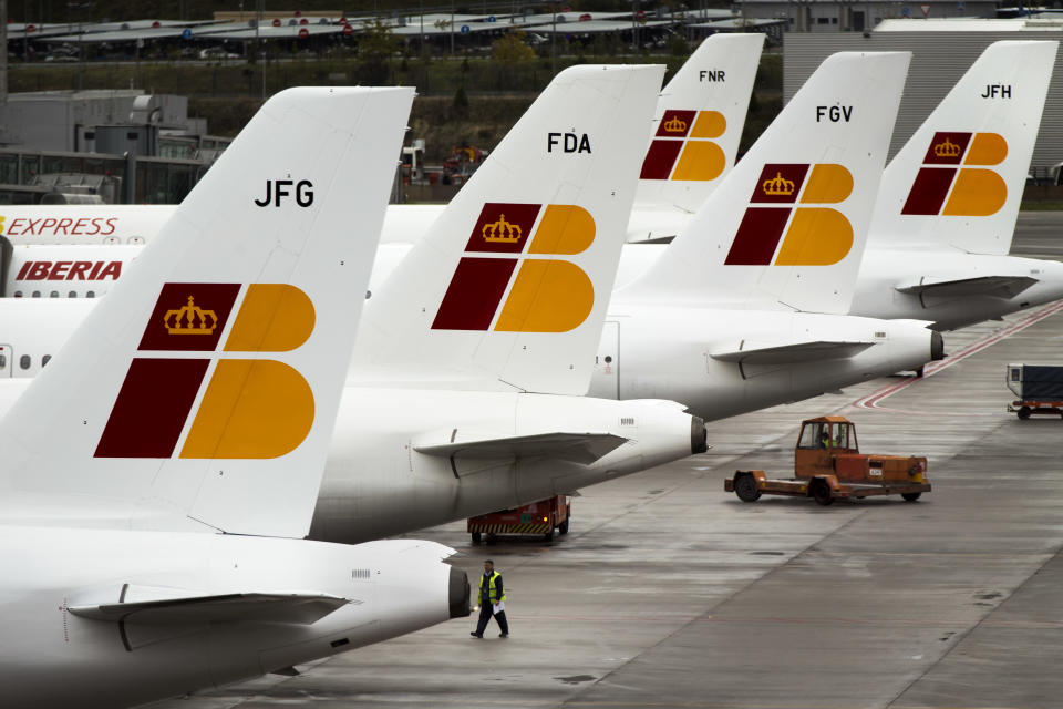 A man walks besides Iberia jets in a parking zone at Barajas international airport in Madrid, Friday, Nov. 9, 2012. International Airlines Group on Friday warned that its Spanish carrier Iberia was "in a fight for survival" and unveiled a restructuring plan to cut 4,500 jobs as it reported a drop in third-quarter profit. (AP Photo/Daniel Ochoa de Olza)