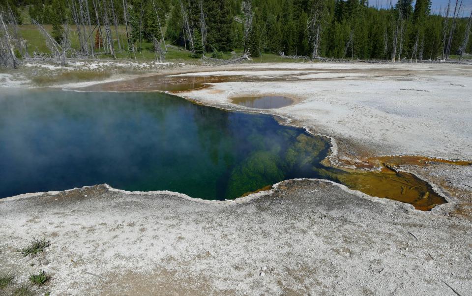 In this photo provided by the National Park Service is the Abyss Pool hot spring in the southern part of Yellowstone National Park, Wy., in June 2015. Park officials are investigating after part of a foot, in a shoe, was found floating in the hot spring on Tuesday, Aug. 16, 2022. (Diane Renkin/National Park Service via AP)