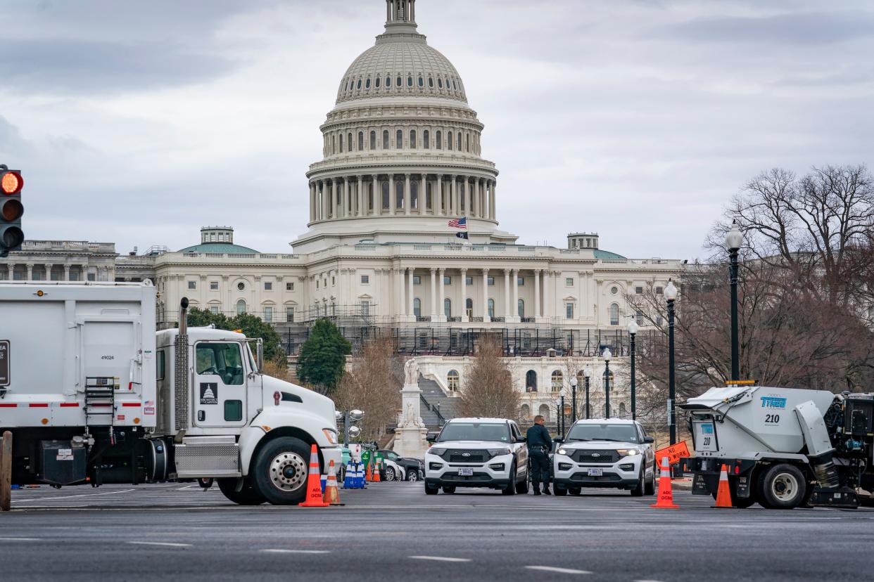Heavy vehicles, including garbage trucks and snow plows, are lined up near an entrance to Capitol Hill in Washington on Feb. 22 amid reports that trucker protests will arrive March 1, the day of President Joe Biden's State of the Union address.