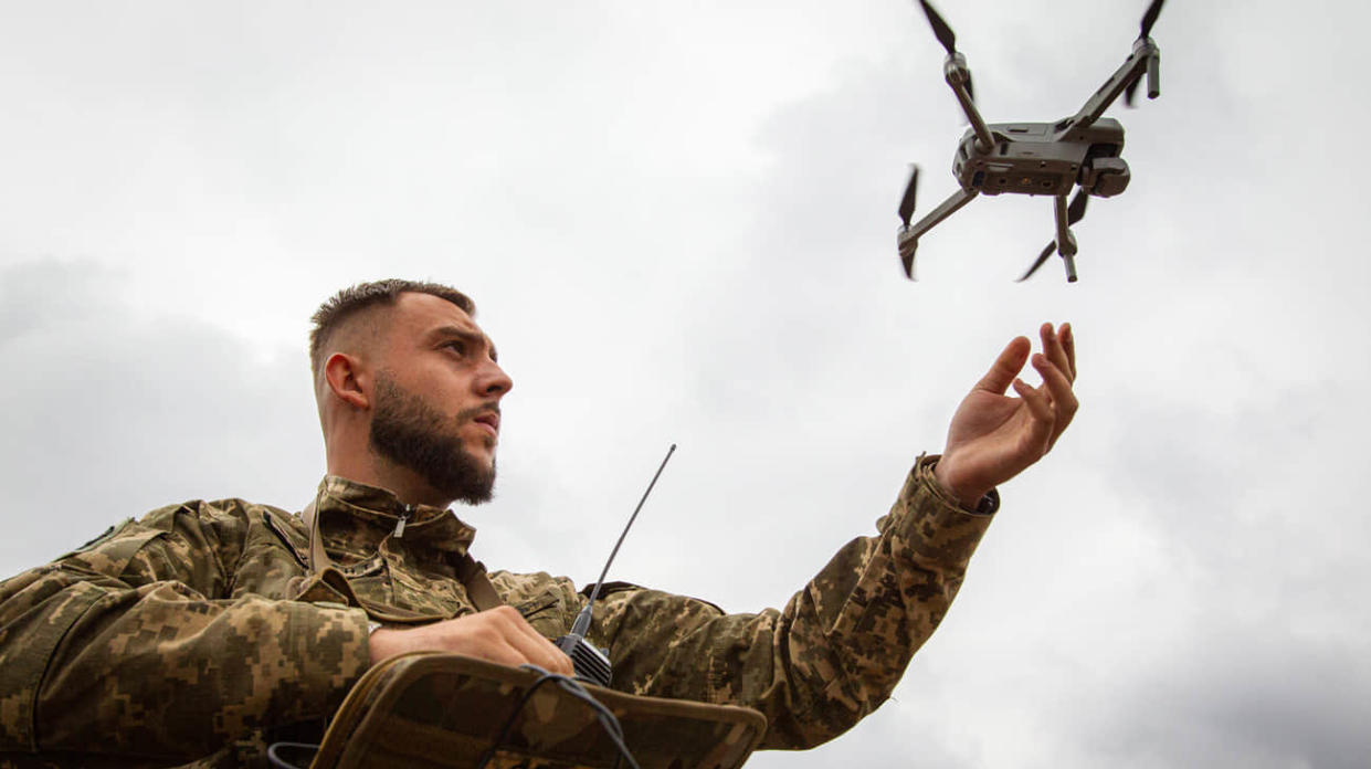 A serviceman launches a drone to demonstrate the integration of AI into the process of humanitarian demining. Photo: Getty Images
