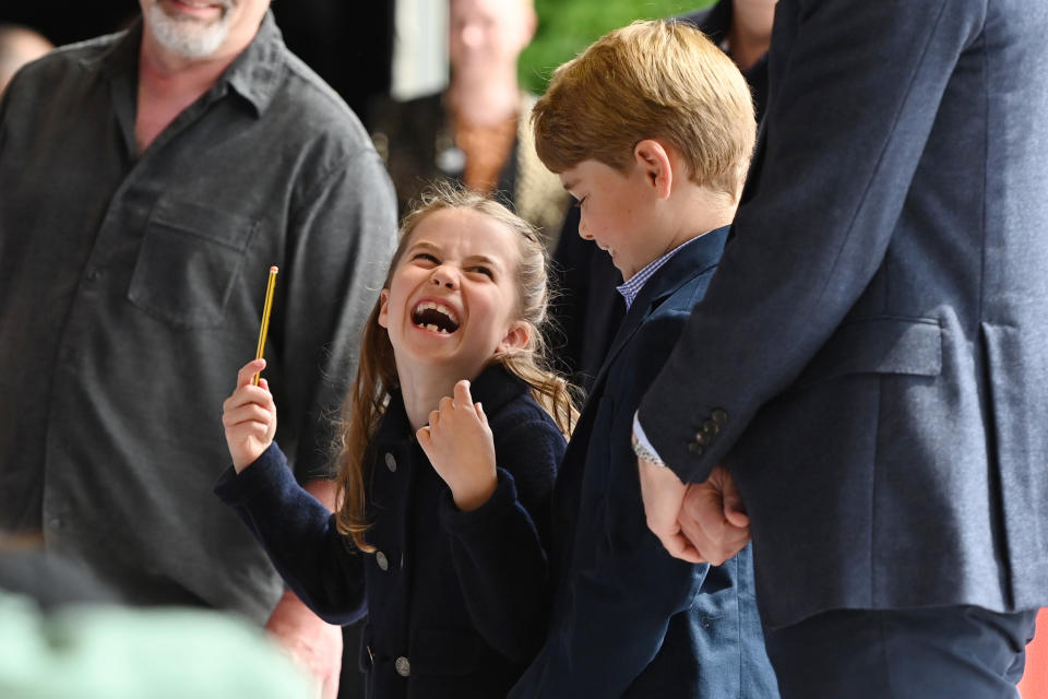 Princess Charlotte laughs as she conducts a band next to her brother, Prince George, during their visit to Cardiff Castle. (PA)