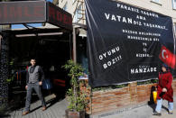 People walk past a cafe offering free food and drinks for those who sell U.S. dollars and submit their receipt in Ankara, Turkey August 16, 2018. Banner reads: "You can live without money but you can't live without a nation. Convert your dollars, come with your receipt, eat and drink on us. Thwart the game" REUTERS/Umit Bektas