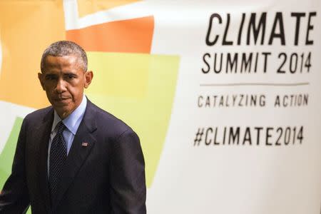 U.S. President Barack Obama walks past a sign after speaking at the Climate Summit at the U.N. headquarters in New York September 23, 2014. REUTERS/Adrees Latif