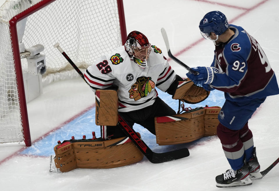 Chicago Blackhawks goaltender Marc-Andre Fleury, left, stops a shot off the stick of Colorado Avalanche left wing Gabriel Landeskog in the first period of an NHL hockey game Wednesday, Oct. 13, 2021, in Denver. (AP Photo/David Zalubowski)