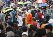 A pro-democracy protester takes a selfie with a clown as they gather during a protest near a main train station in Bangkok, Thailand, Saturday, Oct. 17, 2020. The authorities in Bangkok shut down mass transit systems and set up roadblocks Saturday as Thailand's capital braced for a fourth straight day of determined anti-government protests. (AP Photo/Sakchai Lalit)