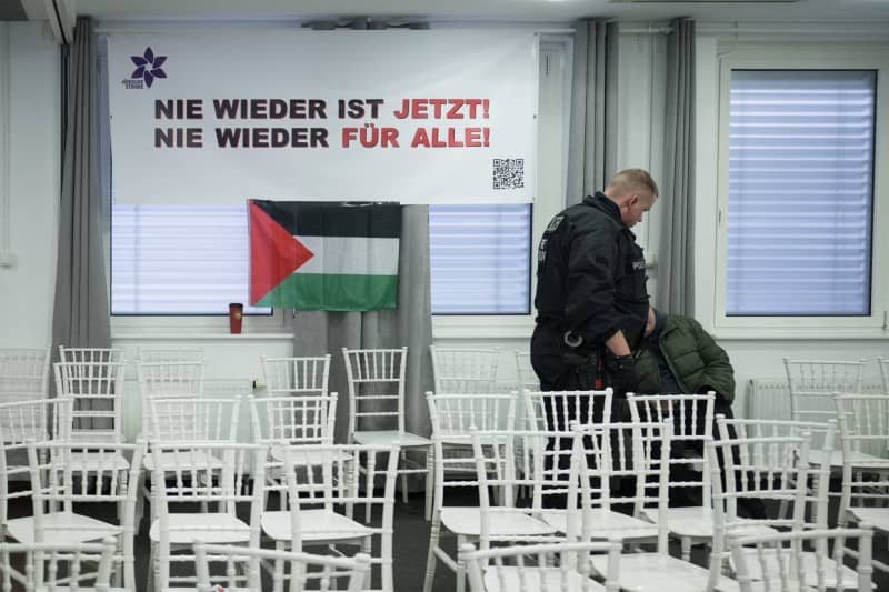 A police officer addresses a participant in the event room after the police broke up the first day of the Palestine Congress 2024. German police on Friday broke up a pro-Palestinian conference in the capital Berlin and asked some 250 participants to leave the venue just two hours into the three-day event. Officers had already intervened in the event during a speech via video by an activist who is banned from political activity in Germany. Sebastian Christoph Gollnow/dpa