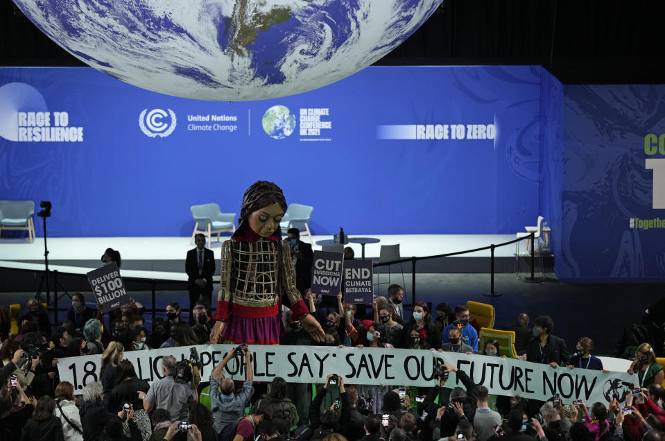 Giant puppet Little Amal walks through the Action Zone inside the venue of the COP26 U.N. Climate Summit in Glasgow, Scotland, Tuesday, Nov. 9, 2021. The U.N. climate summit in Glasgow has entered it's second week as leaders from around the world, are gathering in Scotland's biggest city, to lay out their vision for addressing the common challenge of global warming. (AP Photo/Alastair Grant)