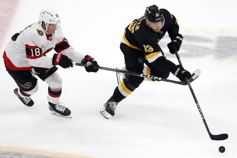 Ottawa Senators' Tim Stützle (18) battles Boston Bruins' Charlie Coyle (13) for the puck during the first period of an NHL hockey game, Monday, Feb. 20, 2023, in Boston. (AP Photo/Michael Dwyer)