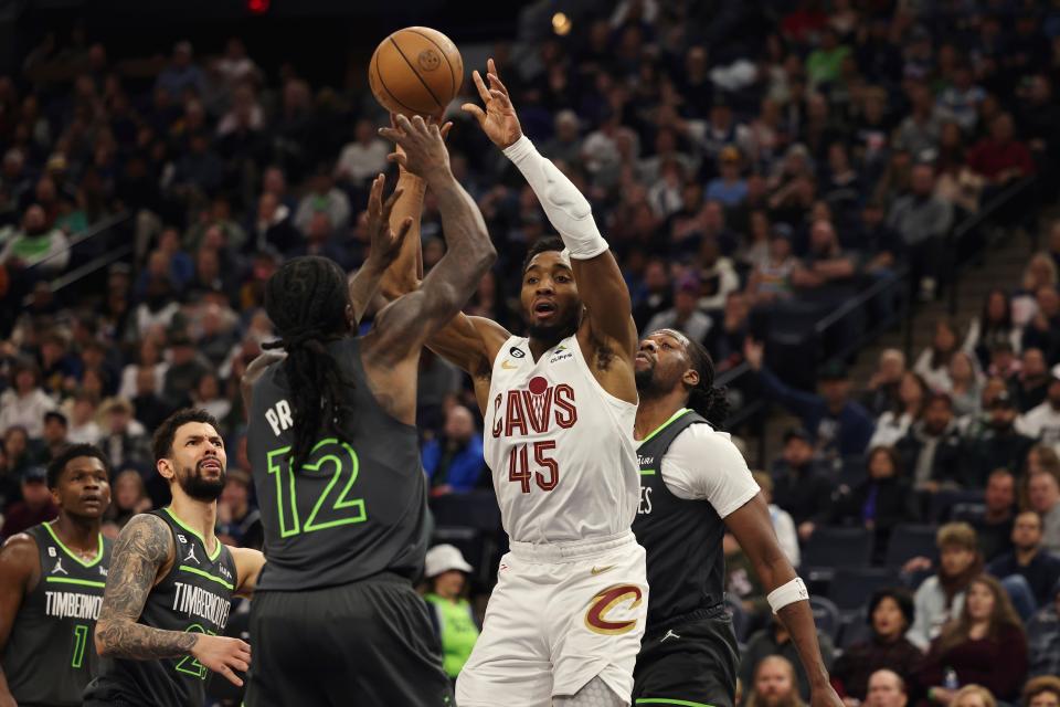 Cleveland Cavaliers guard Donovan Mitchell (45) handles the ball against Minnesota Timberwolves forward Taurean Prince (12) during the second half of an NBA basketball game Saturday, Jan. 14, 2023, in Minneapolis. (AP Photo/Stacy Bengs)