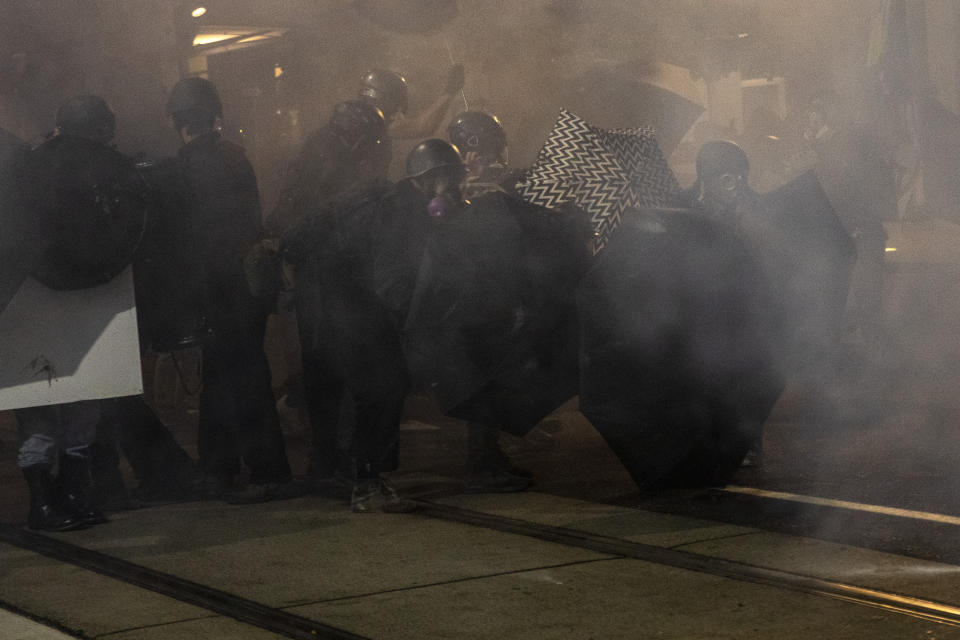 Tear gas fills the air during protests, Friday, Sept. 18, 2020, in Portland, Ore. The protests, which began over the killing of George Floyd, often result frequent clashes between protesters and law enforcement. (AP Photo/Paula Bronstein)