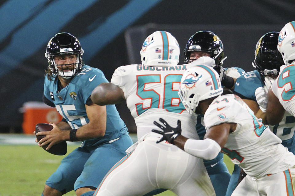 Miami Dolphins defensive tackle Davon Godchaux (56) pressures Jacksonville Jaguars quarterback Gardner Minshew, left, as he looks for a receiver during the first half of an NFL football game, Thursday, Sept. 24, 2020, in Jacksonville, Fla. (AP Photo/Stephen B. Morton)