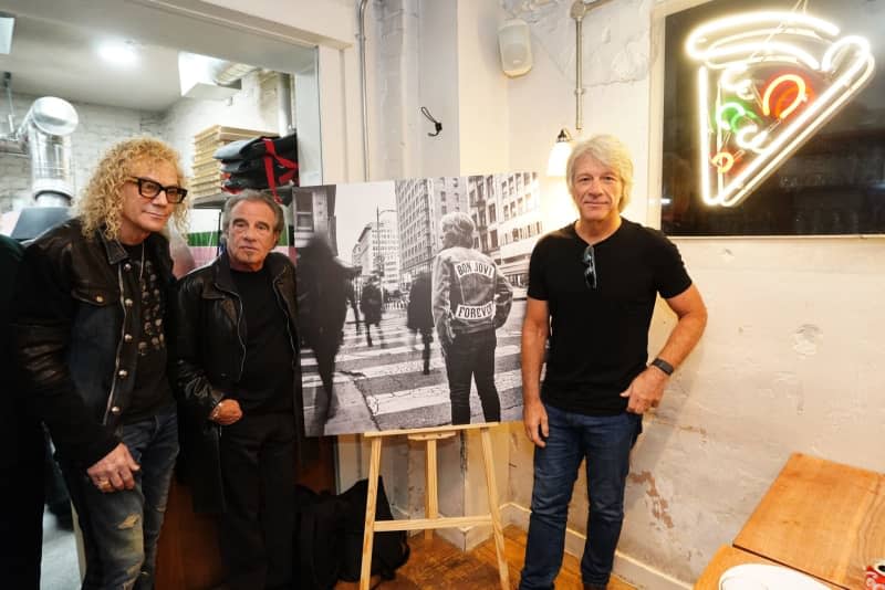 David Bryan, Tico Torres, and Jon Bon Jovi of American rock band Bon Jovi with fans during a pizza party and listening event for their new album "Forever" in central London. Ian West/PA Wire/dpa