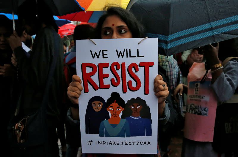 A demonstrator displays a placard as she attends a protest rally against a new citizenship law, in Kolkata