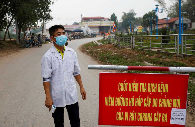 A Vietnamese health worker stands guard at a disease checkpoint of Son Loi commune in Vinh Phuc province