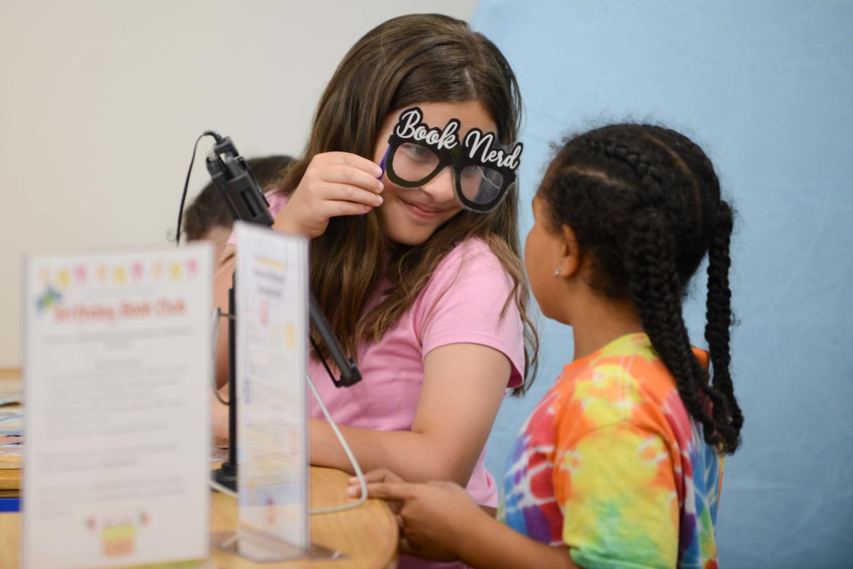 A child dons "Book Nerd" glasses during the Grand Re-Opening of Chester County Library in Henderson, Tenn., on Tuesday, April 30, 2024.