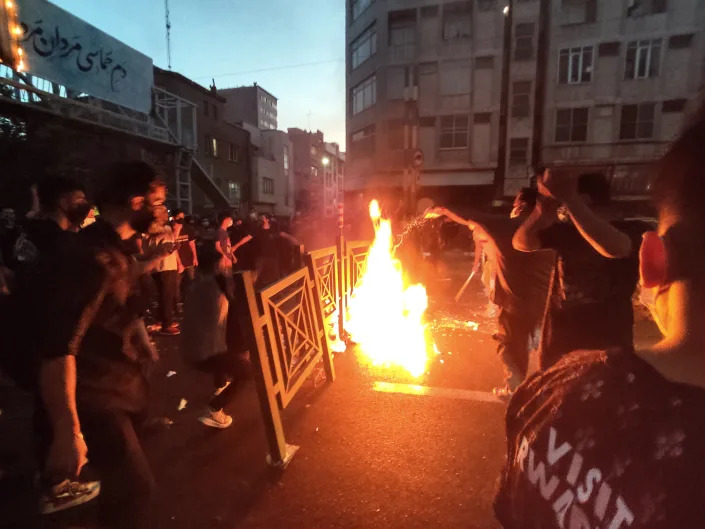 Protesters start a fire in the street.