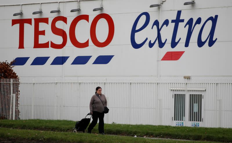 FILE PHOTO: A woman walks past a Tesco extra superstore near Manchester