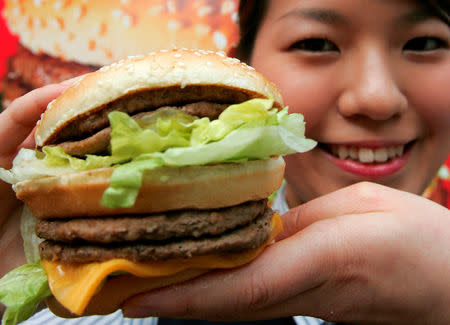 A McDonald's employee displays a Mega Mac burger at a McDonald's outlet in Tokyo April 5, 2007. REUTERS/Toshiyuki Aizawa/File Photo