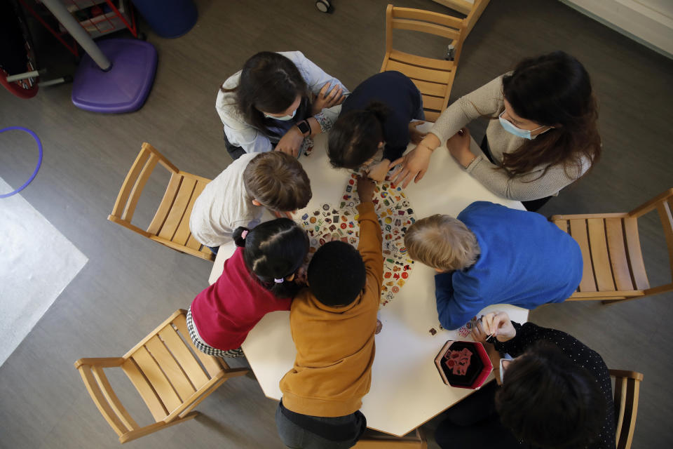 Children play with a therapist in the pediatric unit of the Robert Debre hospital, in Paris, France, Tuesday, March 2, 2021. (AP Photo/Christophe Ena)