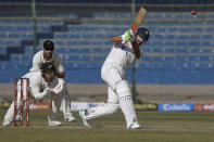 Pakistan's Shan Masood, right, plays a shot as New Zealand's , Tom Blundell, left front, and Daryl Mitchell watch during the second day of the second test cricket match between Pakistan and New Zealand, in Karachi, Pakistan, Tuesday, Jan. 3, 2023. (AP Photo/Fareed Khan)