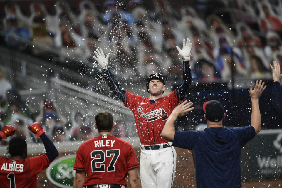 Atlanta Braves' Freddie Freeman, center right, celebrates at home plate as he scores a winning two-run home during the 11th inning of a baseball game against the Boston Red Sox, Friday, Sept. 25, 2020, in Atlanta. (AP Photo/John Amis)