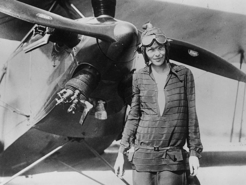 Amelia Earhart, who disappeared without a trace while attempting to fly around the world in 1937, stands  in front of her bi-plane called ‘Friendship’ in Newfoundland on 14 June 1928 (Getty Images)