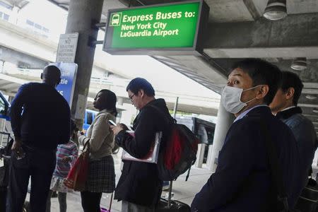 A passenger wears a mask as he exits the International JFK airport in New York October 11, 2014. REUTERS/Eduardo Munoz