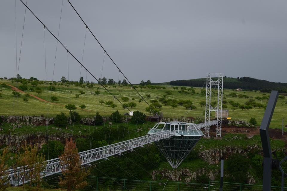 a glass bridge and diamond-shaped bar in the middle, suspended over the Dashbashi Canyon in Georgia