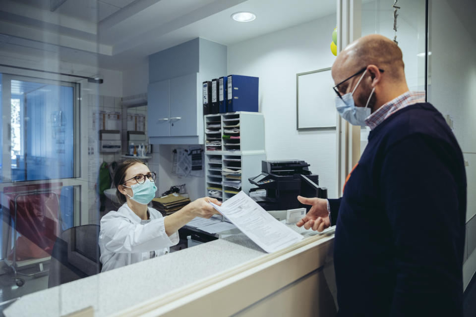 a medical worker handing a patient paperwork