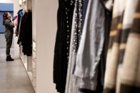 A woman looks at clothes at the Rent The Runway store, an online subscription service for women to rent designer dress and accessory items, in New York City
